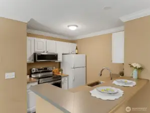 The kitchen with newer stainless steel range & microwave also features white cabinets.