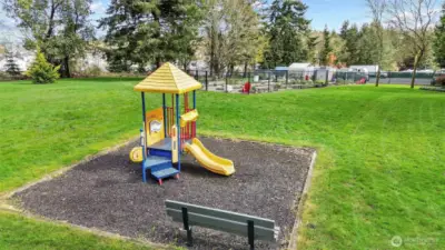 Playground with community garden and RV parking shown in the distance.