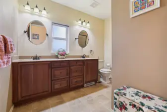 3/4 bathroom with dual sinks and newer cabinetry