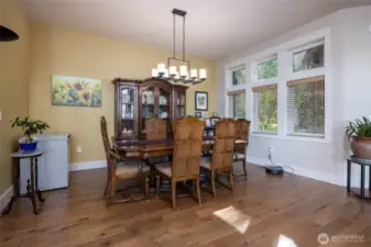 Dining area is tucked between the kitchen and entry and has views out to the forest.