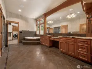 Retreat to comfort in this oversized primary bath with dual vanities, private soaking tub, walk-in shower, and floor-to-ceiling tile. Elegant lighting, built-in linen storage, and direct access to the walk-in closet and laundry area provide a spa-like flow.