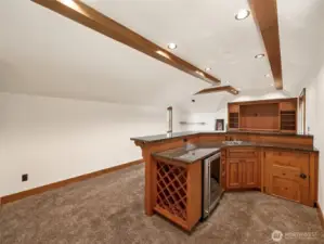 This upstairs bonus space is built for fun and flexibility — with a full wet bar, granite counters, wine rack, undercounter fridge, and seating area. A perfect media lounge, game room, or hosting hub.