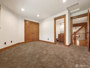 A spacious upstairs bedroom with plush carpet, wood-trimmed doors, and direct access to a full ensuite bath, creating the ideal guest or secondary suite for long stays or multi-generational living.