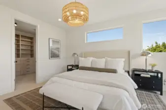 Walk in closet with custom cabinetry flanked off bedroom