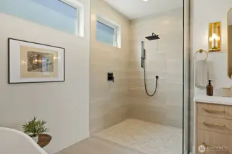 Walk-in shower with river rock tile and travertine surround