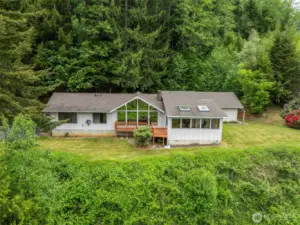 Beautiful lines on this stick-built home on over an acre! Manageable yard, lush green surroundings, sunroom/atrium, large main suite bedroom w/dressing room. Front & rear decks, wood storage, detached garage, carport and attached carport. Call your favorite Realtor today!