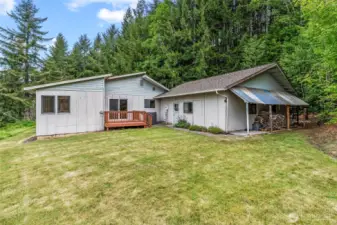 East side of home, additional deck w/slider to dining area; garage entrance, covered wood storage.