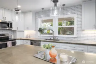 The kitchen in the heart of the home.  Enjoy newer stainless appliances (microwave, range/oven, dishwasher, and fridge/freezer), tons of storage, and a view to the front patio.