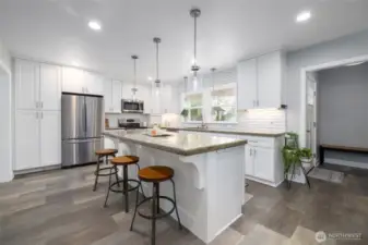 It's the kitchen of your dreams...huge island with seating and storage, tons of drawers and cabinets, pull-out drawers in the built-in pantry, stainless steel appliances (including natural gas range/oven), and so much natural light!  Luxury vinyl tile flooring provides warmth, beauty, and a durable surface for family, friends, and pets.