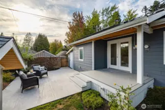 Back patio.  Gate leads to the alley.  Solid white door by the gate leads to a huge storage shed off the garage.