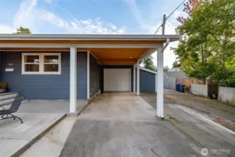 Attached garage and carport.  The siding to the right of garage is a huge storage shed accessible from the back patio.