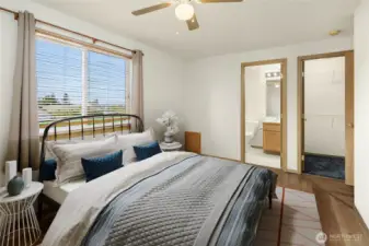 primary bedroom with walk in closet and full bathroom including jetted tub