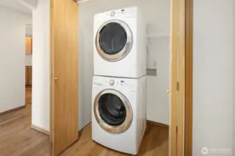 Large utility closet with stacked washer/dryer and plenty of space for storage