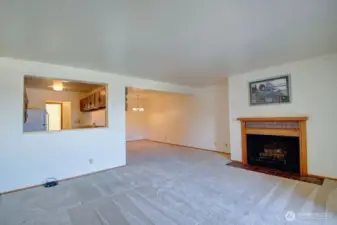 View of fireplace, kitchen and dining area from the corner of the living room.