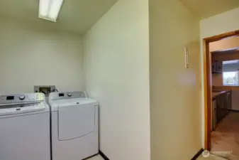 Utility room (across from kitchen) with washer and dryer that stays with the unit.