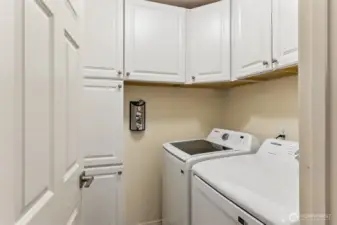 Separate laundry room comes with washer, dryer and cabinets for plenty of extra storage