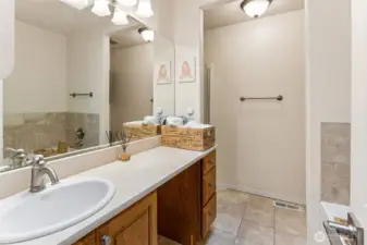 Primary bathroom with tile floors, vanity, separate shower and jetted tub