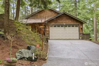 Two car garage with gently sloped drive and lots of parking.