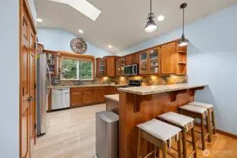 Open kitchen with lots of cabinets and eating bar.
