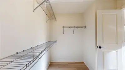 Primary Suite walk-in closet is L-shaped.  As you come through the door and look left, there is another long rod not shown in photograph.