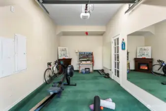 Exercise room in garage has an electric fireplace for those chilly morning workouts.