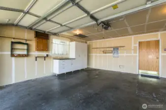 Spacious two car garage with more cabinet storage.