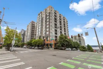 From the sidewalk, take in the full building façade and a glimpse of the nearby shoreline.