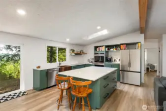 Fully renovated kitchen that's a baker's dream with custom cabinets, quartz countertops, stainless steel appliances including a double oven, and a gorgeous island.