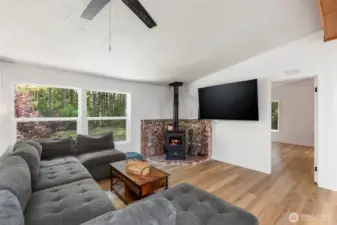 Living room has ample space for all your furnishings, but still cozy with a great corner wood stove. New flooring, windows and paint throughout.