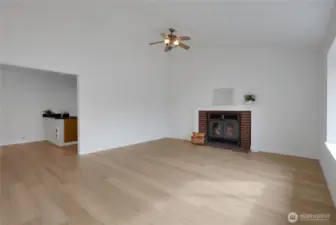 Bright living room with cozy fireplace, new flooring & paint.