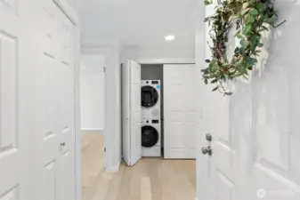A spacious entryway features two hall closets for storage and full size stacked laundry.