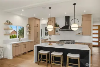 Beautifully appointed chef's kitchen features accent island with waterfall quartz countertop detail