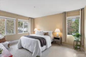Primary bedroom also as an abundance of windows & custom curtains.