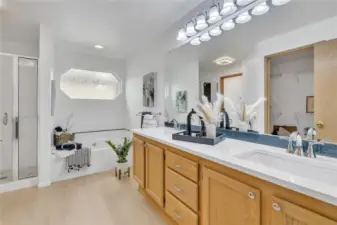 The beautifully remodeled primary 5-piece bath exudes sophistication, showcasing sleek quartz countertops, elegant finishes, a luxurious soaking tub, and a separate, beautifully tiled shower for a spa-like retreat LVP flooring.