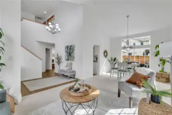 The soaring vaulted ceilings, open floor plan, and expansive windows flood the space with natural light, creating an airy, inviting atmosphere that feels bright and spacious throughout.