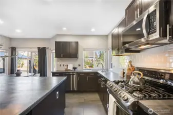 Beautiful, chef-inspired kitchen with modern, stainless appliances, expansive island, corner sink, and even a wine fridge.