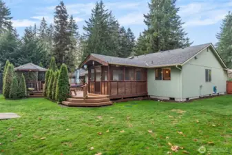 The backyard is fully fenced and boasts an expansive deck, 2 garden sheds & a playhouse/potting shed.