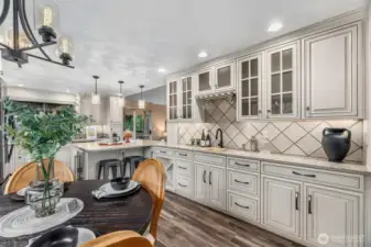 Stunning detail throughout! Love the bar sink, glass display cabinetry & elegant backsplash. Modern light fixtures, recessed, pendant & under cabinet lighting...