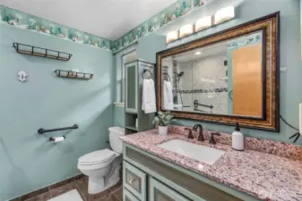 The primary bath with large walk-in shower, ceramic tile flooring & great storage options!