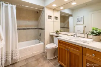 The spacious bathroom is bright & features handsome tile.