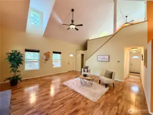 From the dining area, a view of the great room and hallway leading to the guest bedroom on the left, and on the right is the utility room and main bathroom.