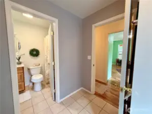 From the utility room, a view of the main floor full bathroom, then leading to the guest bedroom.