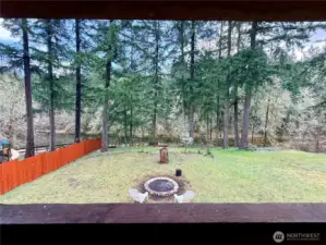 From covered back deck, a view of the backyard and serene pond.