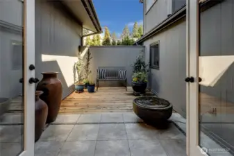 Just beyond, a peaceful courtyard with a fountain provides a private outdoor retreat, ideal for al fresco dining, container gardening, or simply enjoying a cool, shaded escape on warm summer days.