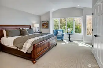 The primary suite is privately positioned on the main level, offering a quiet and secluded retreat. Generously sized and filled with natural light, it enjoys beautiful views of the lake.