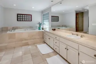 The ensuite bath is equally spacious, featuring a soaking tub, dual sinks, a separate shower, and a towel warmer, creating a spa like experience.