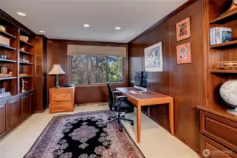 A true work from home office, this spacious and secluded paneled room is wrapped in warm wood, giving it a timeless, library like feel. Custom built in shelves provide abundant space for books and curated treasures