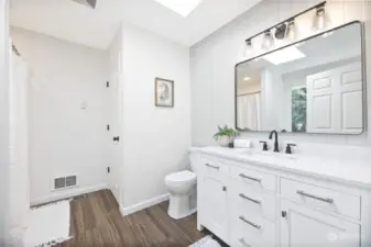 Primary bathroom with soft close doors/drawers, quartz countertops, matte black fixtures, jetted tub, walk-in shower and shiplap! Plumbed for stackable washer and dryer or convert to linen closet for additional storage!