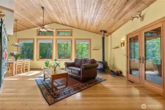 Wall of windows frames serene forest, meadow, and mountain views.