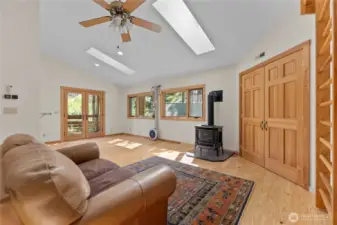 Versatile upstairs bonus room with skylights, private balcony, and propane stove—ideal as a yoga room, office suite, or creative retreat. Includes dance bar and inspiring natural light.
